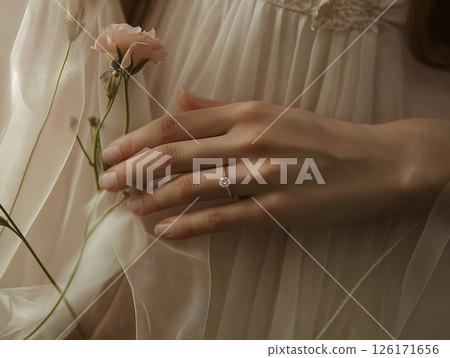 Bride's hand with wedding ring against cream wedding dress, elegant and intimate detail shot. Bride's hand with wedding ring against cream wedding dress, elegant and intimate detail shot. 126171656