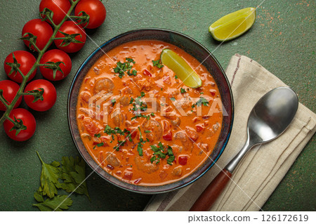 Brazilian traditional dish moqueca de camarao with shrimps, tomatoes, peppers, and lime in a bowl top view Brazilian traditional dish moqueca de camarao with shrimps, tomatoes, peppers, and lime in a bowl top view 126172619