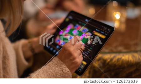 Engaging in an online poker game at a social gathering in a cozy atmosphere 126172639