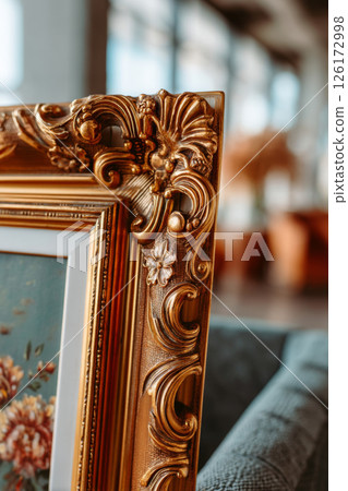 Gilded Rococo-style picture frame corner in elegant interior with floral artwork 126172998