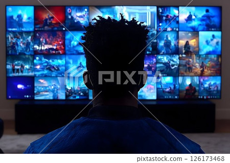 Man engrossed in multiple screens displaying video game streams at home 126173468