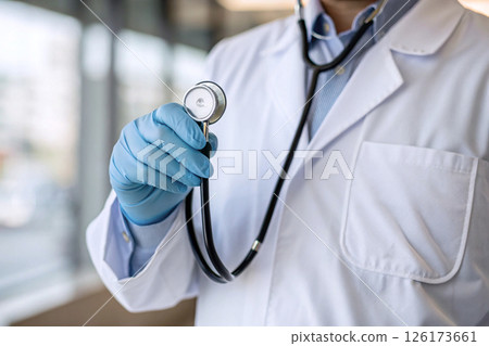A doctor in a white coat with a stethoscope in the hospital. 126173661