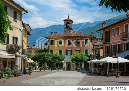 Picturesque italian town square with colorful buildings and a mountain view on a sunny summer day 126174710