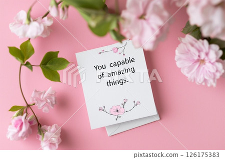 Inspiring greeting card featuring the motivational phrase you are capable of amazing things surrounded by delicate floral illustrations on a pink background 126175383