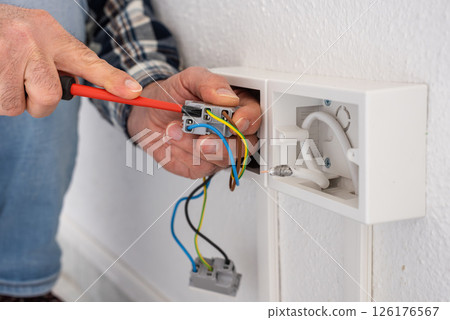 Electrician at work on a residential electrical system. Electricity. 126176567