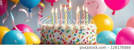 Colorful birthday celebration with cake, candles, and balloons at a festive party setting 126176866