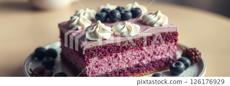 Delicious layered cake topped with cream and fresh blueberries on a rustic wooden table 126176929