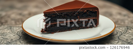Delicious chocolate cake slice served on elegant plate with intricate design and rich allure 126176946