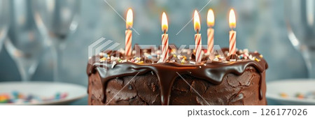 Five lit candles on a chocolate cake celebrating a special occasion 126177026