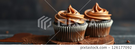 Delicious chocolate cupcakes with fluffy frosting displayed on a wooden board in an elegant arrangement 126177092