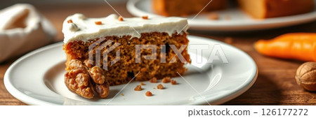 Delicious carrot cake slice with cream frosting served on a white plate in a cozy kitchen setting 126177272