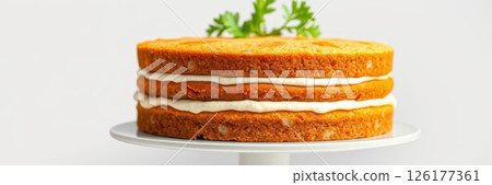 Delicious layer cake on a white stand decorated with fresh herbs and inviting frosting 126177361