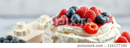 Delicious dessert featuring fresh berries on a fluffy cream cake at a cozy indoor setting 126177390