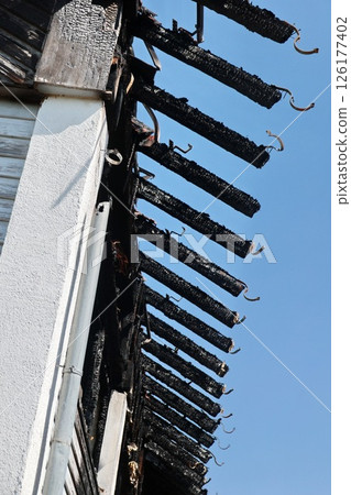A building with a black roof and a blue sky 126177402