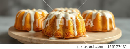 Delicious mini bundt cakes on a marble platter with creamy drizzle ready to be served for dessert 126177481
