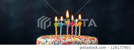 Celebrating a birthday with a colorful cake topped with lit candles in a festive atmosphere 126177901