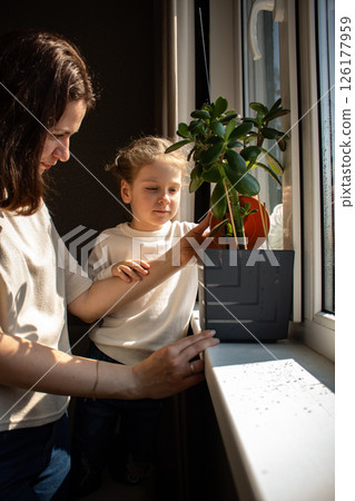 4 years old girl and her mom engage in plant care. Illustrating gentle parenting and eco habits. Image for educational materials, parenting guides, and home gardening content. 4 years old girl and her mom engage in plant care. Illustrating gentle parenting and eco habits. Image for educational materials, parenting guides, and home gardening content. 126177959