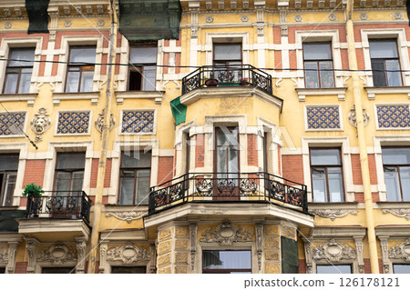 Minimalist architecture building facade of old historic house exterior. Decorative ornamental design elements of classic European style apartment building front view in Saint Petersburg, Russia Minimalist architecture building facade of old historic house exterior. Decorative ornamental design elements of classic European style apartment building front view in Saint Petersburg, Russia 126178121