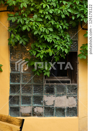 Interior Street cafe. Old window with flowers and French-style cafe table. Decor facade of coffee house. Interior Street cafe. Old window with flowers and French-style cafe table. Decor facade of coffee house. 126178122