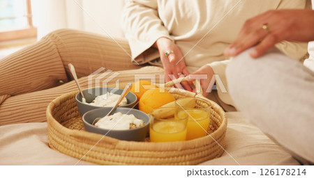 Home, couple and hands in bed for breakfast, nutrition and bonding together on weekend holiday. Closeup, morning and people with food for wellness, healthy diet or porridge with orange juice in house 126178214