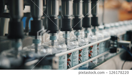 Machine, bottles and alcohol at distillery for production, manufacturing or gin drink in warehouse. Factory, packaging or beverage with equipment for supply chain, logistics or liquor filling process 126178220