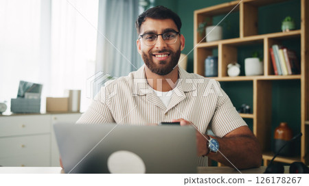 Home, man and laptop with smartphone in portrait, chat and online story for freelancer. House, remote work and content writer with technology for research, social media and article website in office 126178267