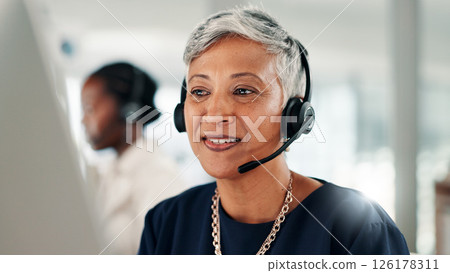 Happy, mature woman or consultant with headset on computer for online advice or customer service. Female person, agent or employee talking with mic or technology for virtual assistance at call center 126178311