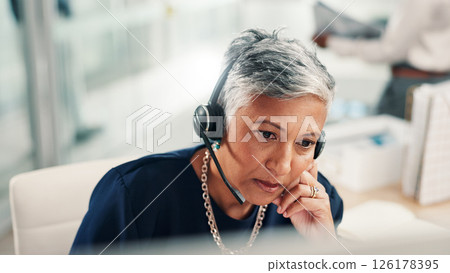 Thinking, office and mature woman in call center with stress for contact us, crm service or customer support. Business, professional consultant and person with headset for problem solving on computer 126178395