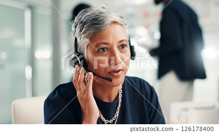 Mature woman, consultant and talking with headset at call center for online communication. Female person, agent or employee speaking with mic or technology for virtual assistance or help at office 126178400
