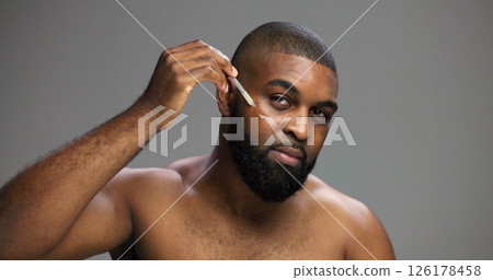Serum, beauty and portrait of black man in studio for salon, grooming and dermatology. Cosmetics, glow and self care with person and oil dropper on gray background for hydration, skincare and shine 126178458