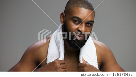 Shower, skincare and portrait of black man in studio for beauty, grooming and dermatology. Cosmetics, glow and self care with person and towel on gray background for hydration, hygiene and shine 126178482