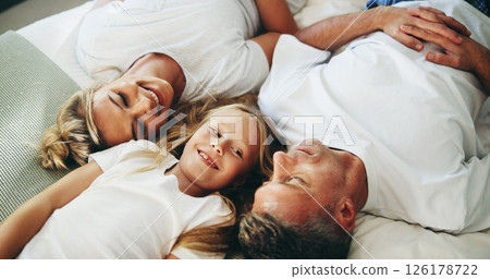 Smile, parents and child relax on bed with love, security and bonding together in bedroom. Happy, people and resting with girl for support, care and family relationship for weekend break at house Smile, parents and child relax on bed with love, security and bonding together in bedroom. Happy, people and resting with girl for support, care and family relationship for weekend break at house 126178722