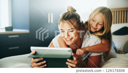 Happy mom, daughter and relax with tablet on bed for online entertainment, show or cartoon at home. Mother, child or kid lying with smile on technology for subscription, app or streaming in bedroom Happy mom, daughter and relax with tablet on bed for online entertainment, show or cartoon at home. Mother, child or kid lying with smile on technology for subscription, app or streaming in bedroom 126178806