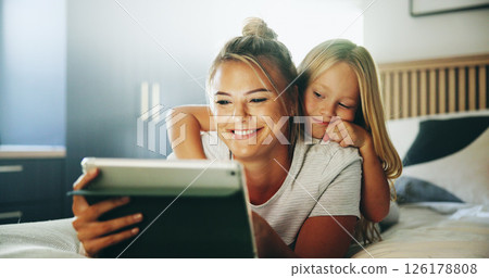 Happy mom, child and relax with tablet on bed for online entertainment, show or cartoon at home. Mother, daughter or kid lying with smile on technology for subscription, app or streaming in bedroom Happy mom, child and relax with tablet on bed for online entertainment, show or cartoon at home. Mother, daughter or kid lying with smile on technology for subscription, app or streaming in bedroom 126178808