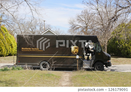 UPS Delivery Truck delivering package outdoor with sky and trees UPS Delivery Truck delivering package outdoor with sky and trees 126179091