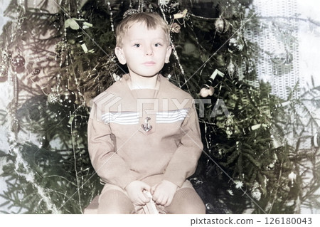Vintage portrait of little boy near a Christmas tree. Retro photo from 1970. 126180043