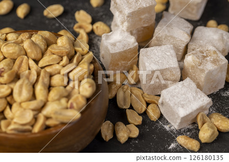 square Turkish delight in powdered sugar with nuts inside, scattered oriental sweets Turkish delight with peanuts 126180135