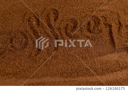 The word coffee written on a ground coffee for preparation of a drink, roasted ground coffee in large quantities 126180175