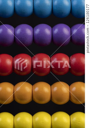 wooden abacus for play, wooden children's abacus for learning and development, on a black background, side view wooden abacus for play, wooden children's abacus for learning and development, on a black background, side view 126180177