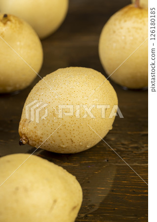 wet sweet pears of white color with spots on the skin closeup, in drops of water, The pear is reflected in the table 126180185