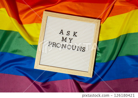 ASK MY PRONOUNS text Neo pronouns concept on Rainbow flag background gender pronouns. Non-binary people rights transgenders. Lgbtq community support assume my gender tolerance equal rights ASK MY PRONOUNS text Neo pronouns concept on Rainbow flag background gender pronouns. Non-binary people rights transgenders. Lgbtq community support assume my gender tolerance equal rights 126180421
