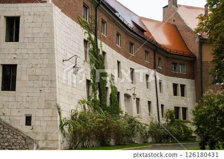 Summer view of Wawel Royal Castle in Krakow, Poland. Historical place in Poland. Flowers on foreground. Beautiful sightseeing with Wawel Royal Castle and colorful flowers in Krakow, Poland Summer view of Wawel Royal Castle in Krakow, Poland. Historical place in Poland. Flowers on foreground. Beautiful sightseeing with Wawel Royal Castle and colorful flowers in Krakow, Poland 126180431