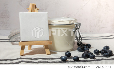 Glass jar with natural organic homemade yogurt and blueberries on table. Immunity-boosting ingredients Copy space empty note. Concept of healthy eating breakfast of Greek yogurt Glass jar with natural organic homemade yogurt and blueberries on table. Immunity-boosting ingredients Copy space empty note. Concept of healthy eating breakfast of Greek yogurt 126180484