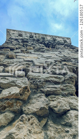 Ancient historical tower from stone bricks low angle view. 126180517