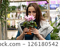 Woman in a florist smelling a flower 126180542