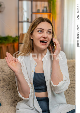 Adult happy woman talking on smartphone at home, laughing sincerely expressing joyful communication Adult happy woman talking on smartphone at home, laughing sincerely expressing joyful communication 126180652