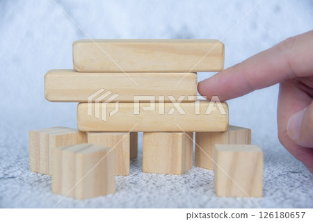 Hand pointing empty wooden blocks with customizable space for text. 126180657