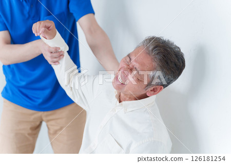 Elderly man with shoulder pain and staff Elderly man with shoulder pain and staff 126181254