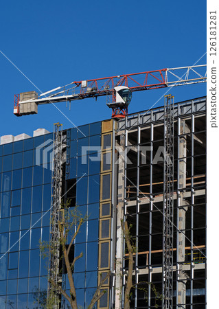 Building construction, glazing the facade of an office building. Object under construction. Installation of glass curtain wall. Glass wall of a monolithic building under construction. Building construction, glazing the facade of an office building. Object under construction. Installation of glass curtain wall. Glass wall of a monolithic building under construction. 126181281