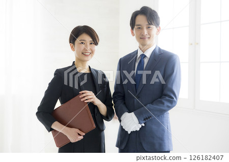 身著西裝、微笑的男士和女士拿著文件 身著西裝、微笑的男士和女士拿著文件 126182407
